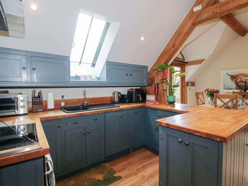 A kitchen with blue cabinets and wooden counters at Pultheley Cottage Hyssington near Churchstoke