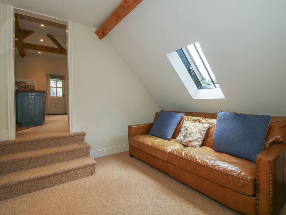 A seating area with a sofa and staircase at Pultheley Cottage in Hyssington near Churchstoke