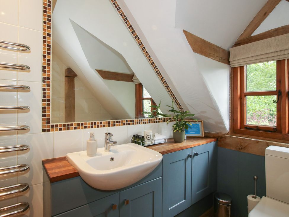 A bathroom with sink and mirror at Pultheley Cottage near Hyssington
