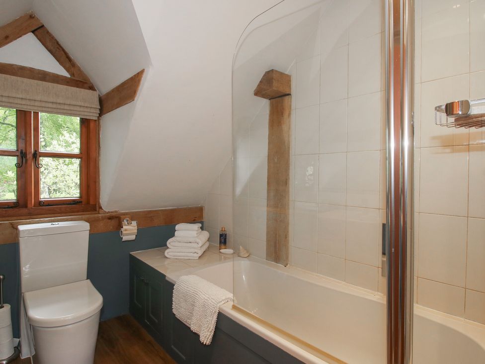 A bathroom with a toilet and bathtub at Pultheley Cottage in Hyssington near Churchstoke