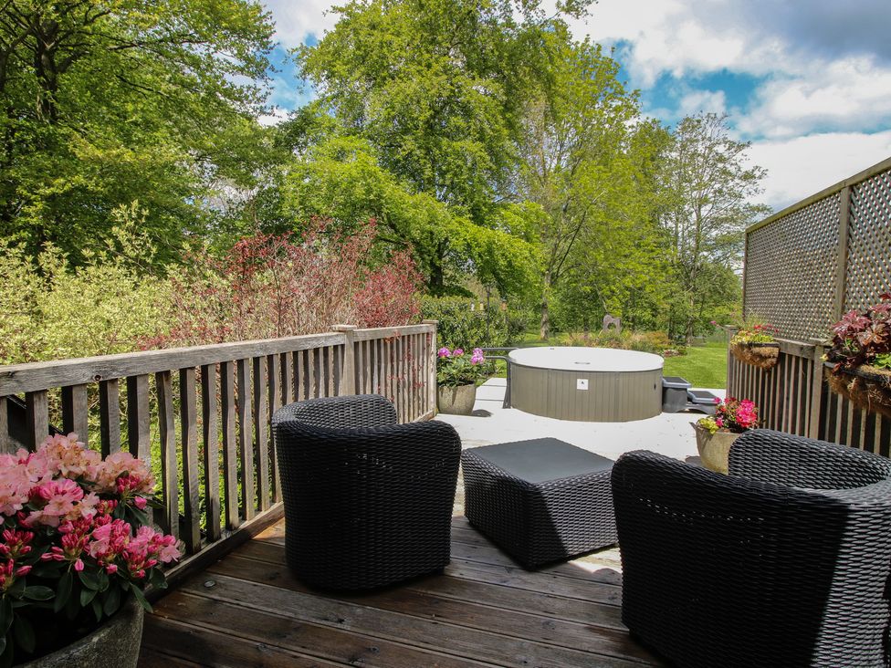 An outdoor area with chairs, a table, and a hot tub at Pultheley Cottage Hyssington near Churchstoke