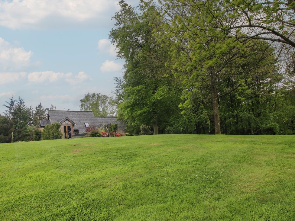 A house surrounded by grass and trees at Pultheley Cottage in Hyssington near Churchstoke