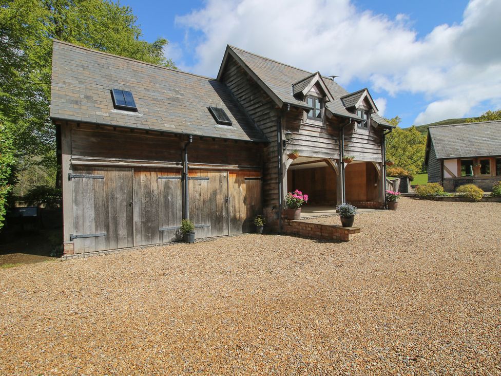 A building with garage doors and planters at Pultheley Cottage Hyssington near Churchstoke
