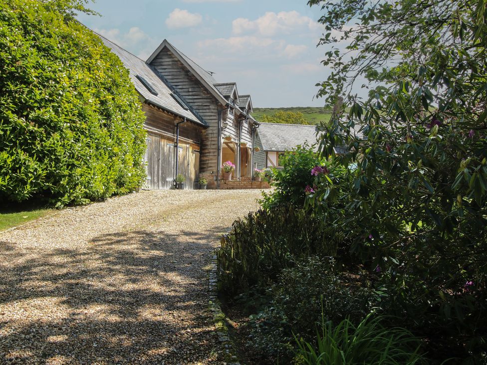 A gravel path leading past wooden buildings at Pultheley Cottage Hyssington near Churchstoke