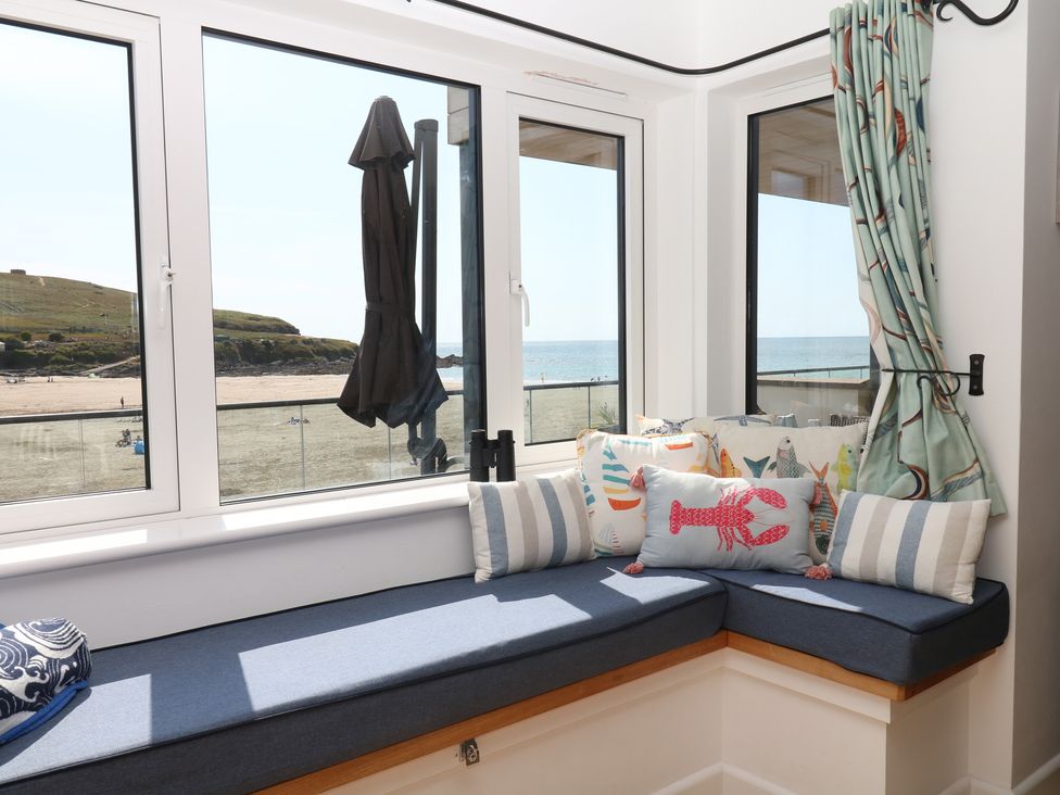 A sunroom with a sea view and cushions at 4 Burgh Island Causeway Bigbury