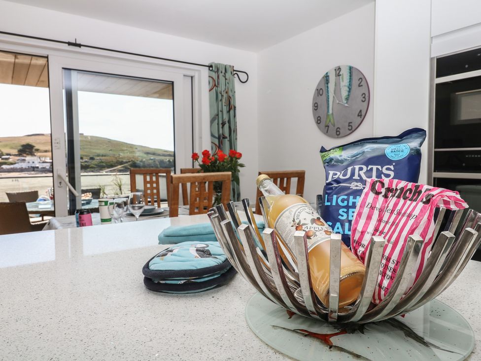 A kitchen with a bottle and snacks on the counter at 4 Burgh Island Causeway Bigbury