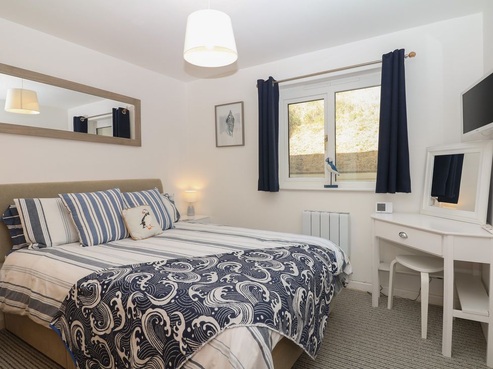 A bedroom with a bed and a dressing table at 4 Burgh Island Causeway in Bigbury