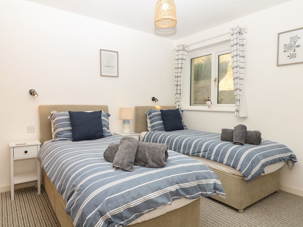 A bedroom with two beds and a window at 4 Burgh Island Causeway Bigbury