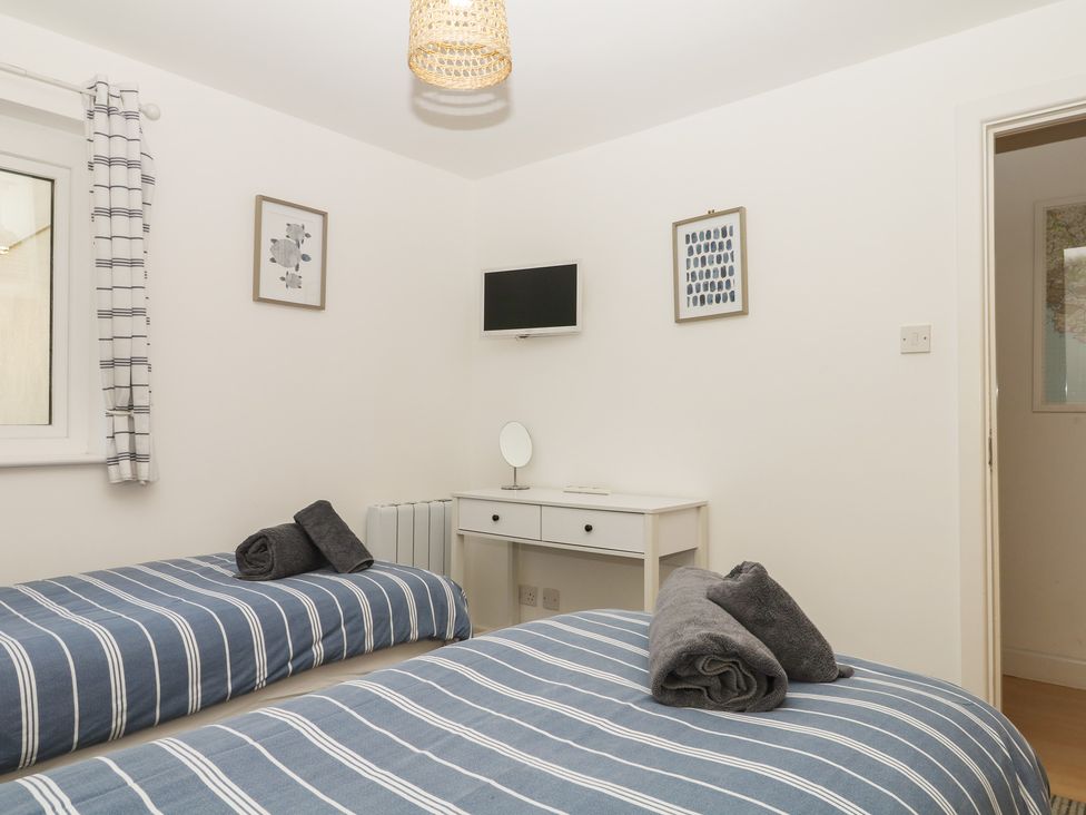 A bedroom with two beds and a desk at 4 Burgh Island Causeway in Bigbury