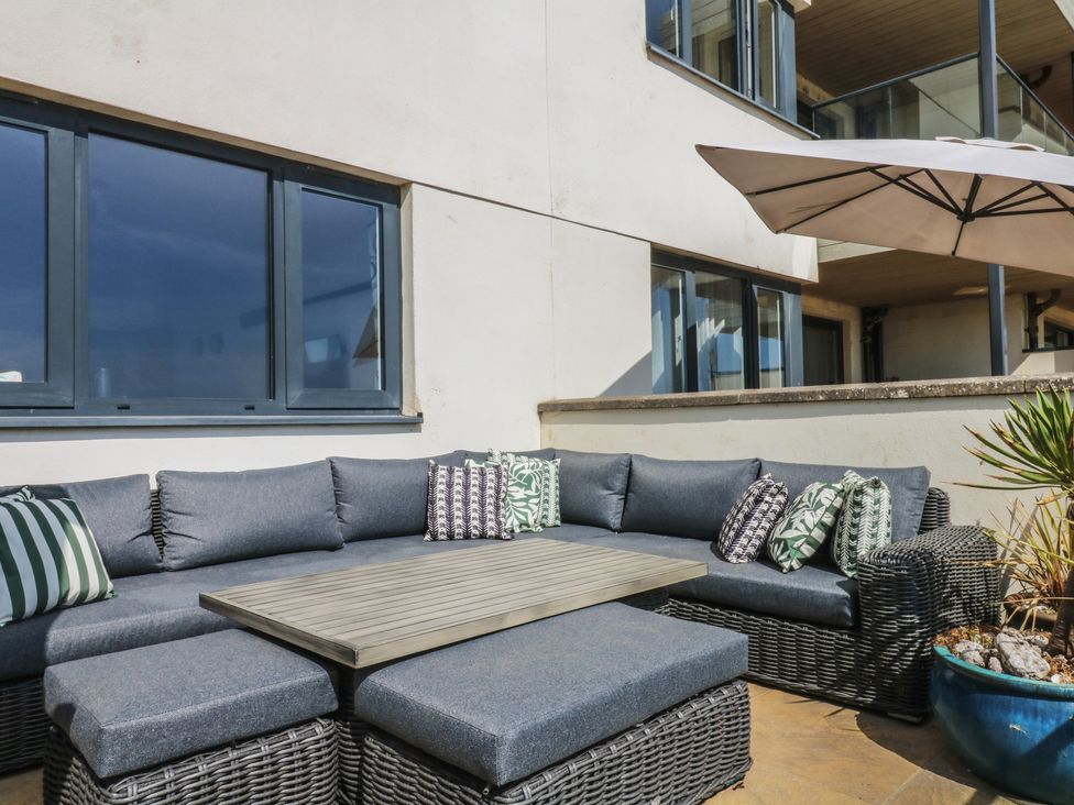 An outdoor seating area with a sectional couch and table at 4 Burgh Island Causeway Bigbury