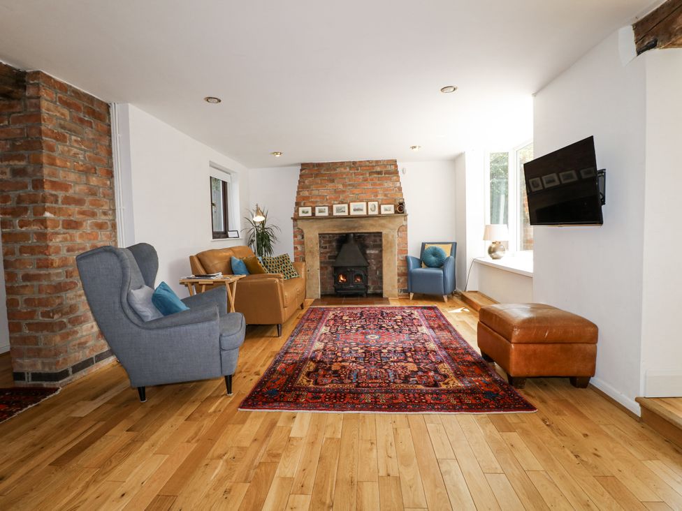 A living room with a fireplace and sofa at 35 Main Street in Gunthorpe near Lowdham