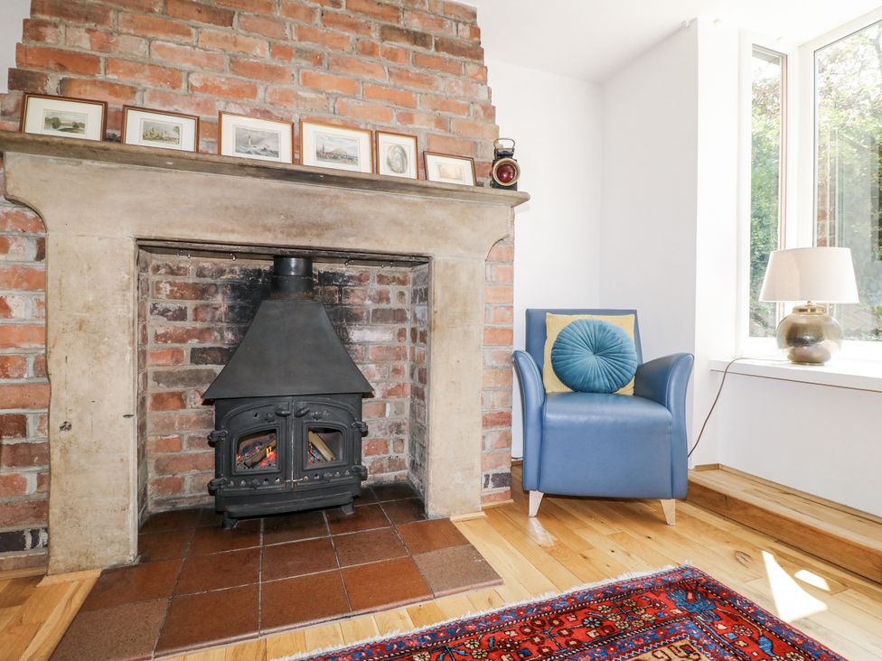 A living room with a fireplace and a blue chair at 35 Main Street Gunthorpe near Lowdham
