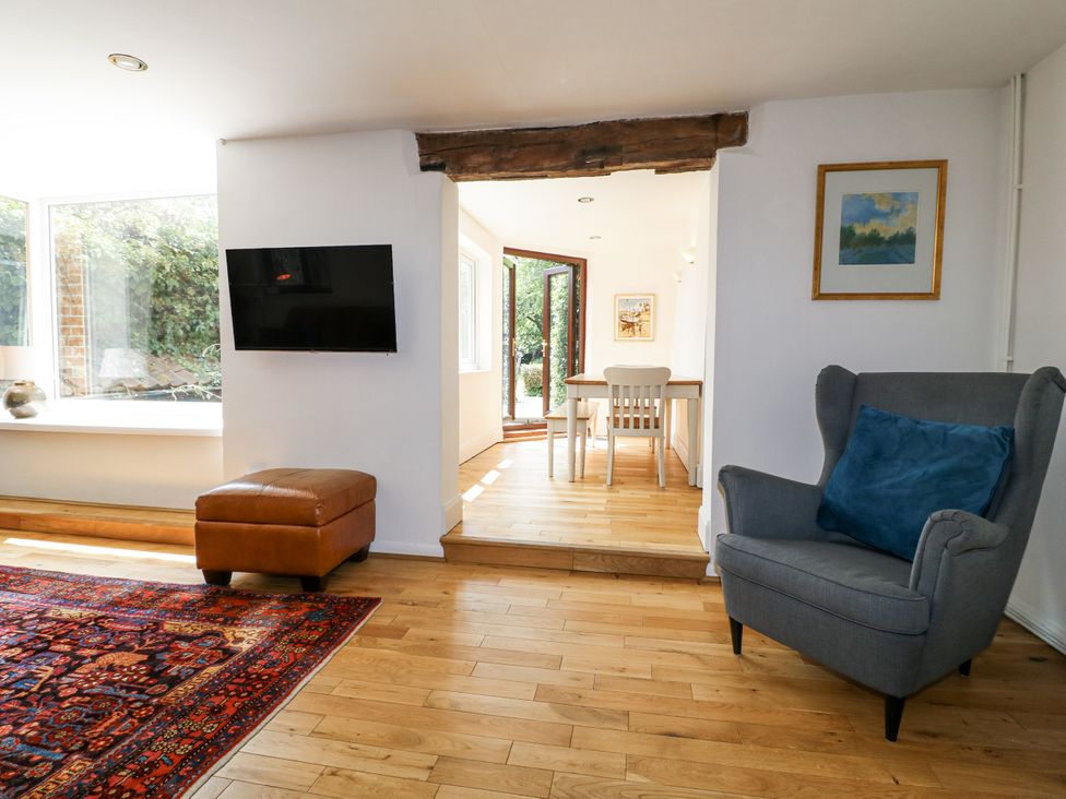 A living room with a television and an ottoman at 35 Main Street in Gunthorpe near Lowdham