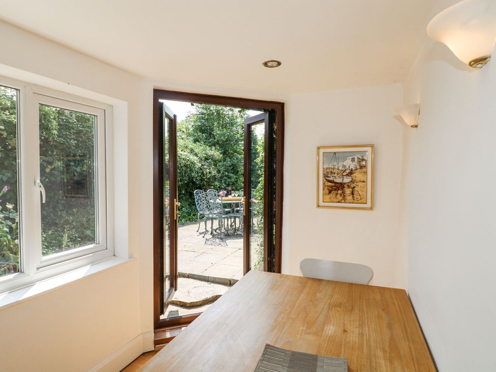 A dining room with a table and chairs leading to a garden at 35 Main Street Gunthorpe near Lowdham