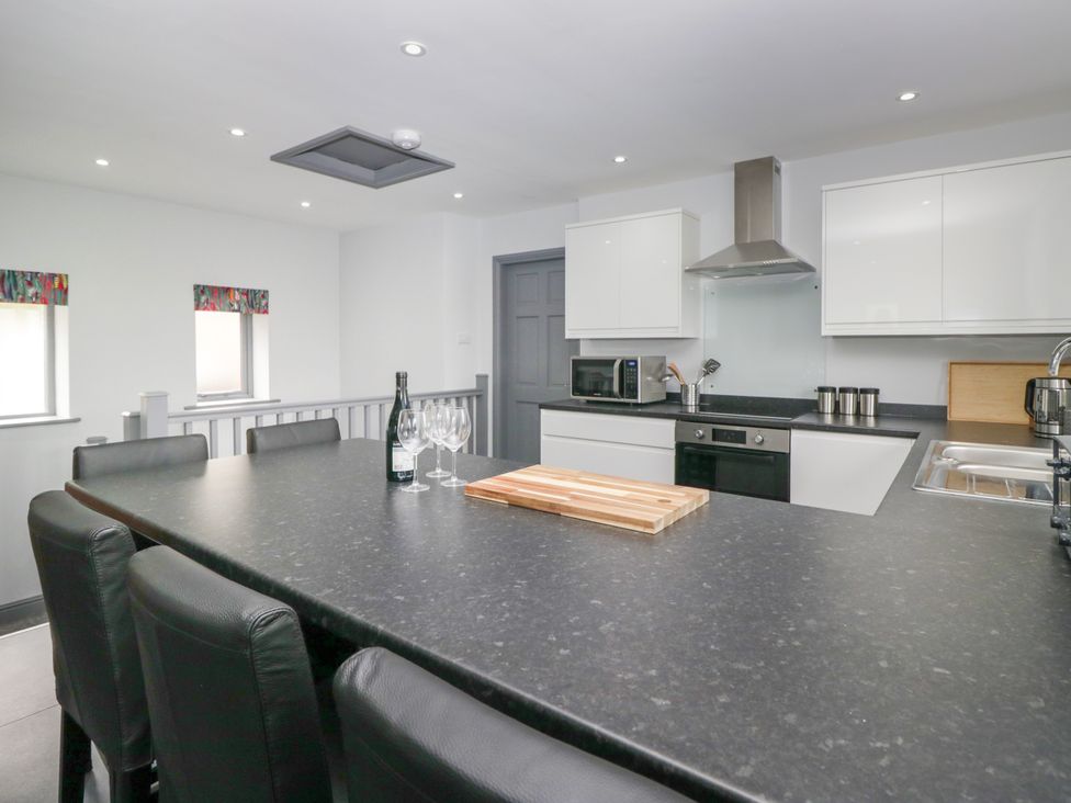 A kitchen with a table and stools at Fell View Cottage in Lambrigg near Kendal