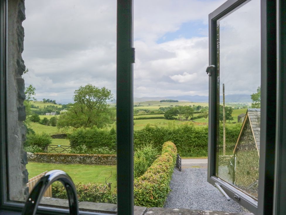 A view from a window showing fields and trees at Fell View Cottage Lambrigg near Kendal