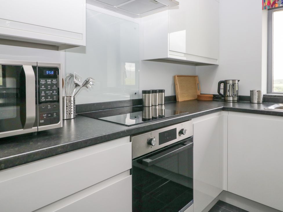 A kitchen with microwave, kettle, and kitchen utensils at Fell View Cottage in Lambrigg near Kendal
