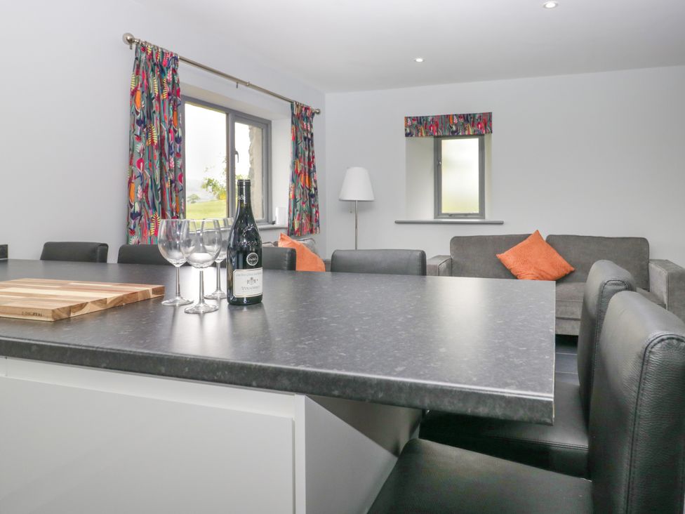 A kitchen with a cutting board and wine bottles at Fell View Cottage in Lambrigg near Kendal