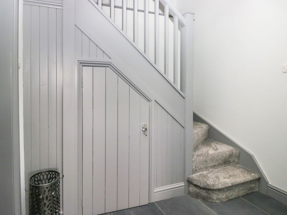 A hallway with stairs and a door at Fell View Cottage in Lambrigg near Kendal