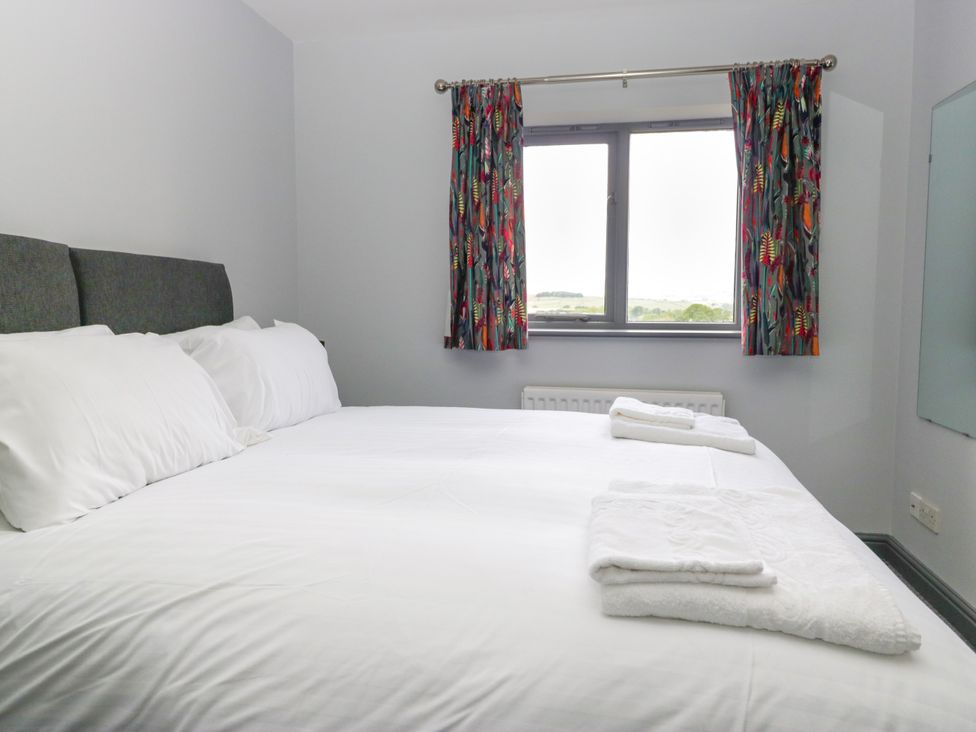A bedroom with a bed and curtains at Fell View Cottage Lambrigg near Kendal