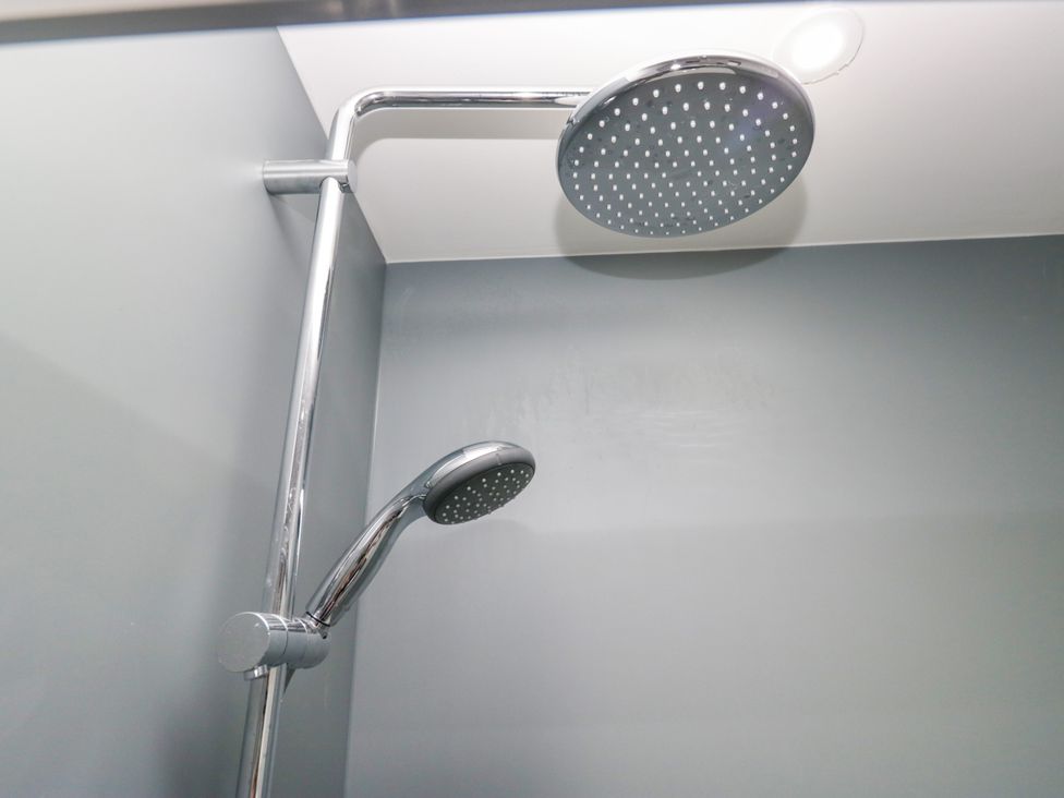 A shower head and arm in a bathroom at Fell View Cottage Lambrigg near Kendal