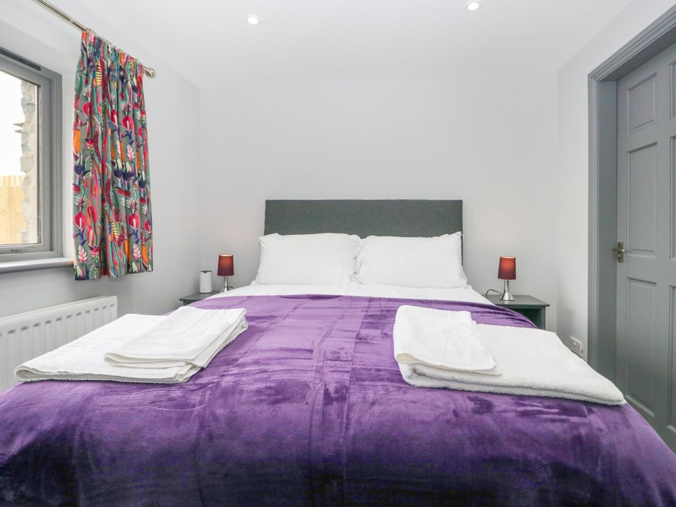 A bedroom with a bed and curtains at Fell View Cottage in Lambrigg near Kendal