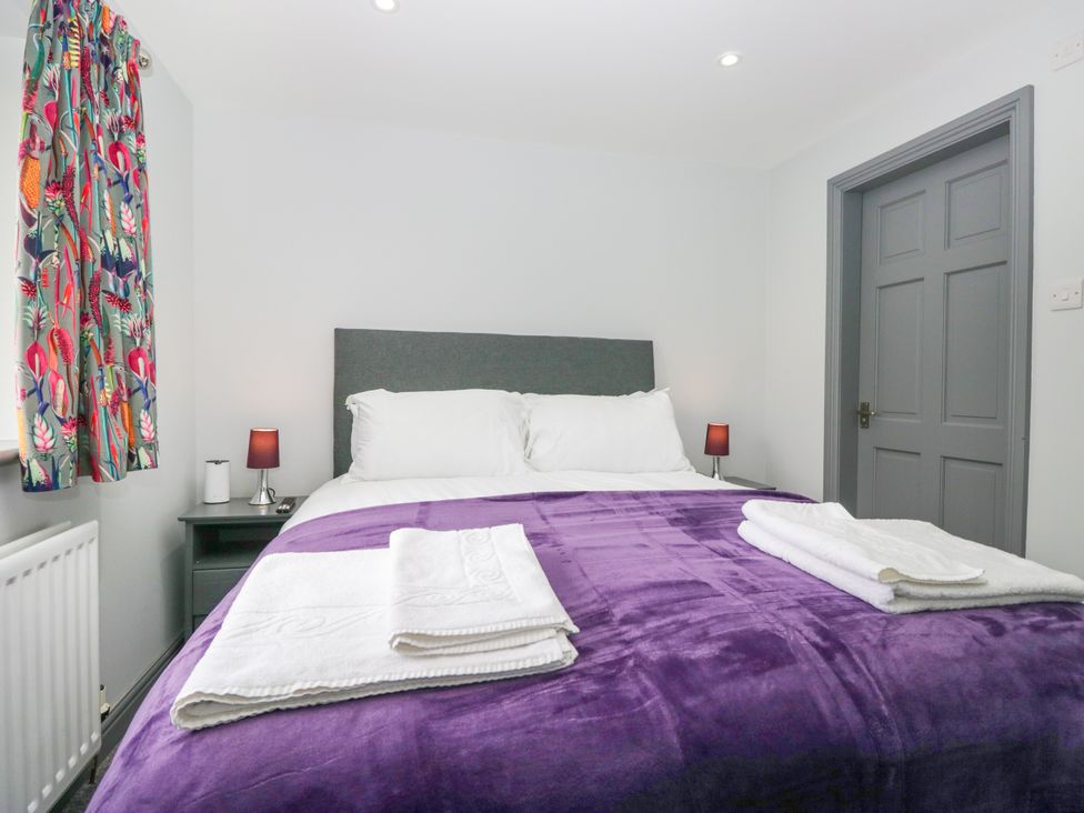A bedroom with a double bed and colorful curtains at Fell View Cottage Lambrigg near Kendal