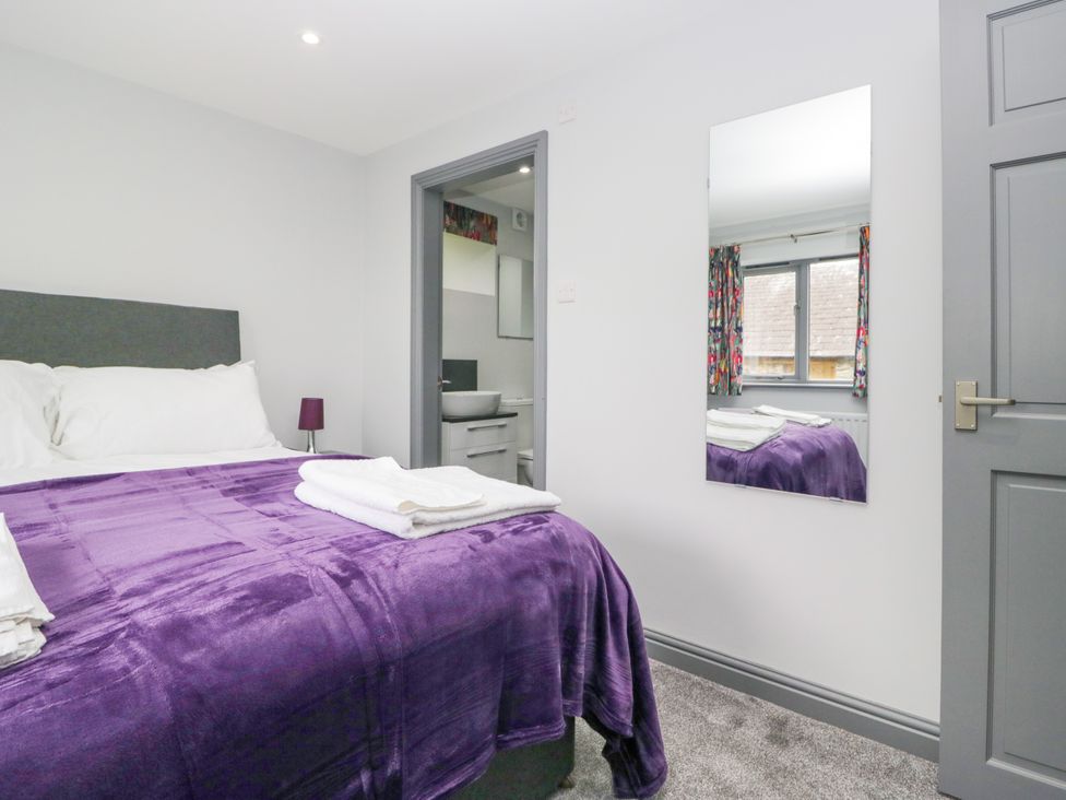 A bedroom with a bed and mirror at Fell View Cottage Lambrigg near Kendal