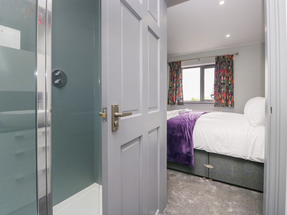 A bedroom with a bed and curtains at Fell View Cottage in Lambrigg near Kendal