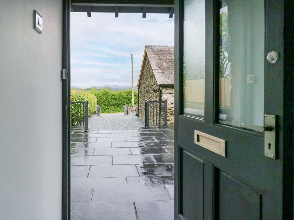 An entrance view with a door open to a path and building at Fell View Cottage Lambrigg near Kendal