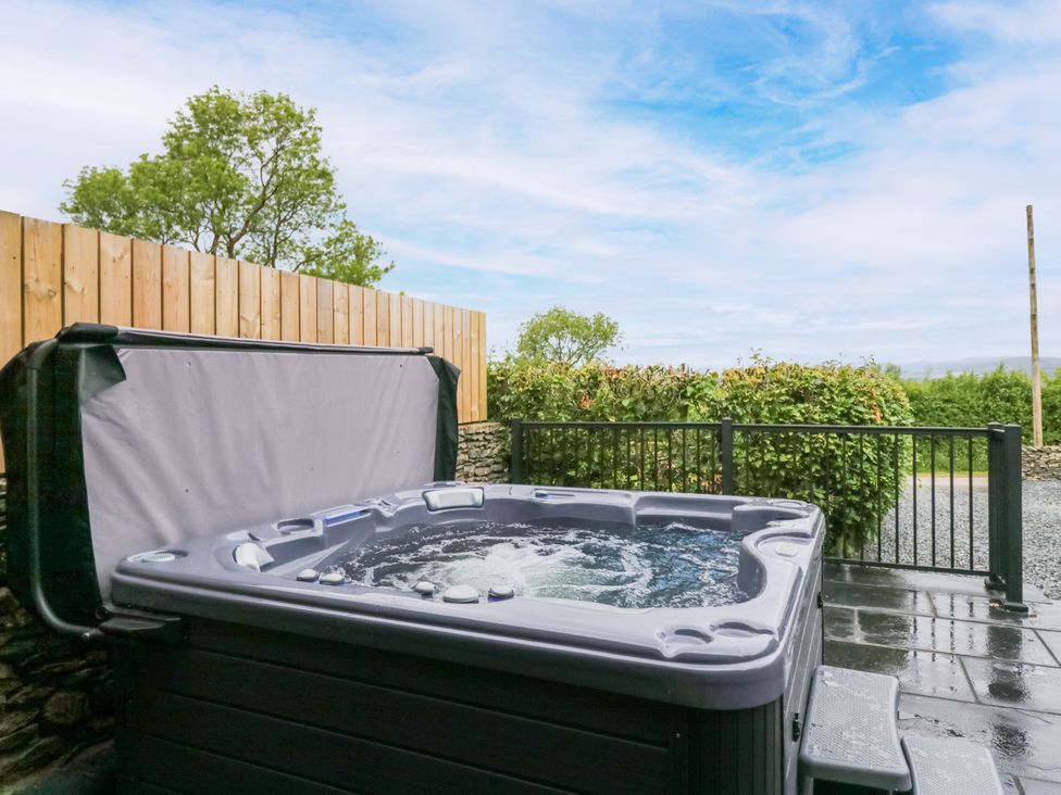 A hot tub with a cover in an outdoor area at Fell View Cottage in Lambrigg near Kendal