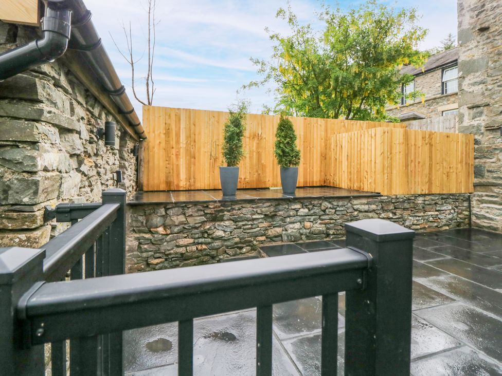 An outdoor area with a stone wall and wooden fence at Fell View Cottage Lambrigg near Kendal