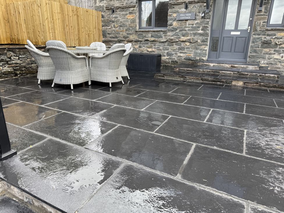 An outdoor seating area with a table and chairs at Fell View Cottage in Lambrigg near Kendal