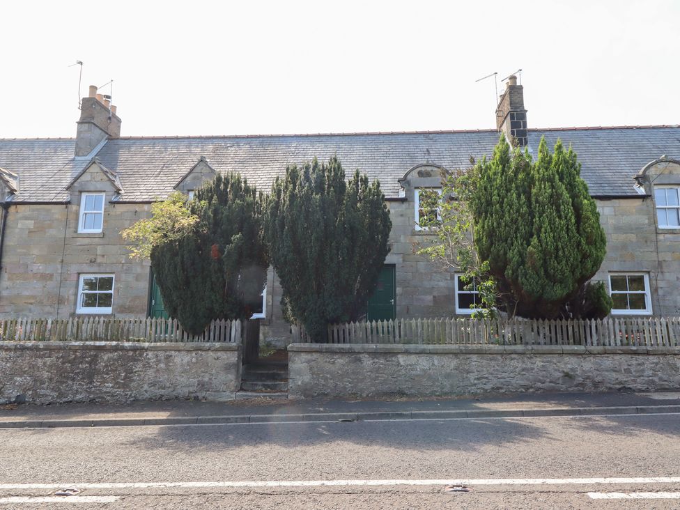 A house with trees and a fence at Bruno's Bothy Middleton near Belford