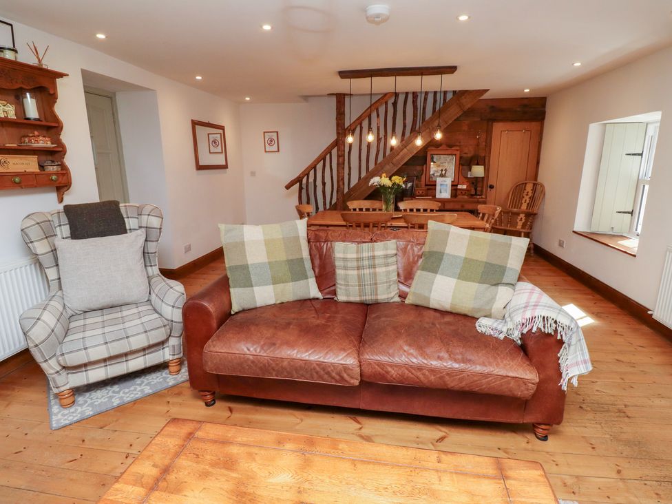 A living room with a sofa and armchair at Bruno's Bothy Middleton near Belford