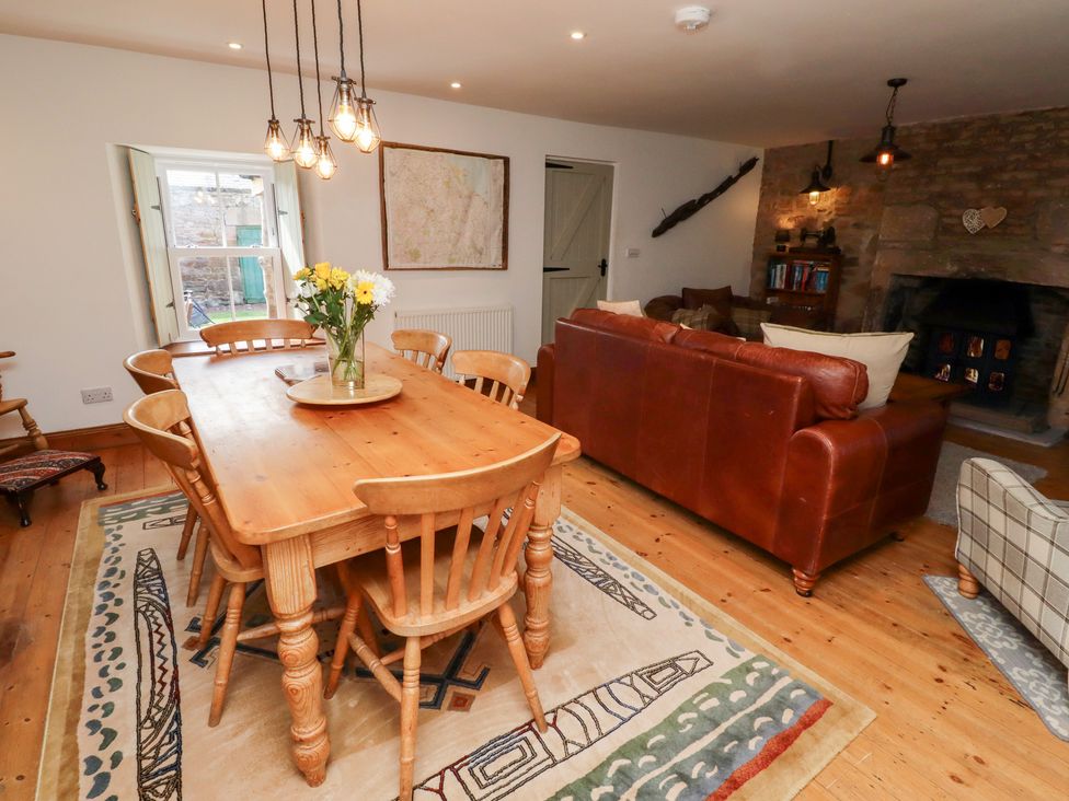 A dining room with wooden table and chairs at Bruno's Bothy Middleton near Belford