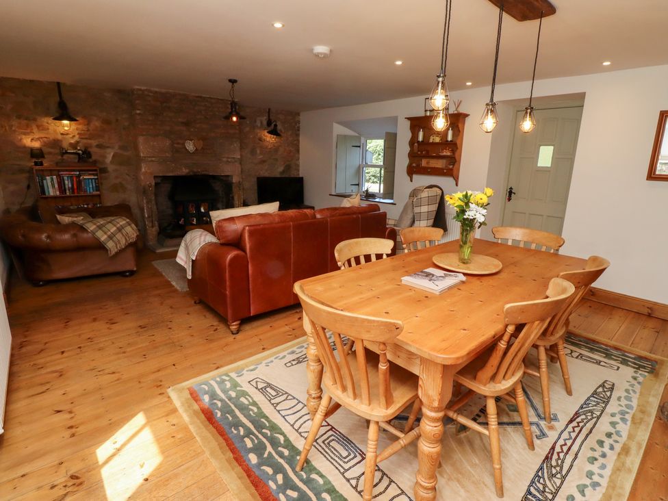 A dining room with a wooden table and chairs at Bruno's Bothy Middleton near Belford