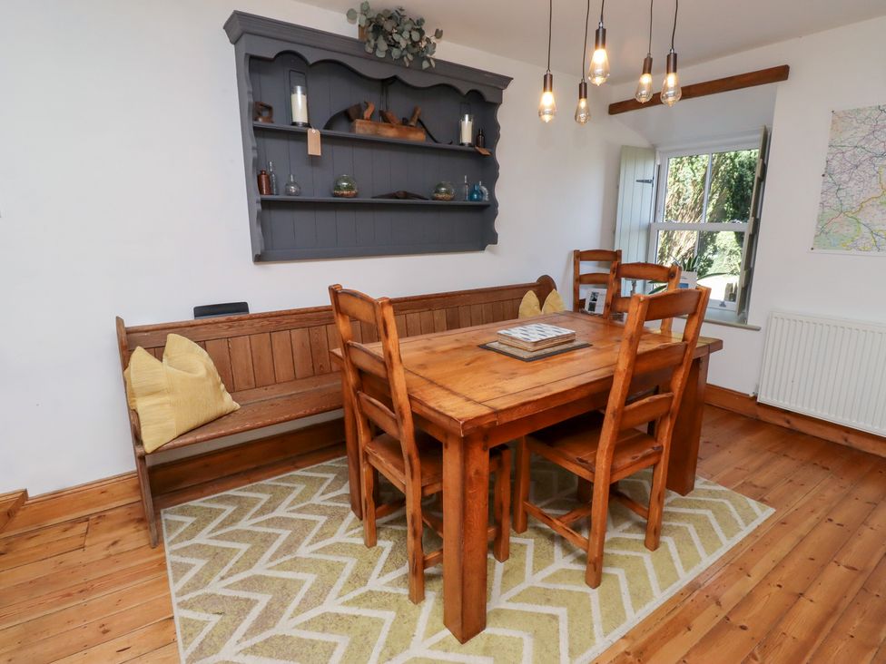 A dining room with a wooden table and chairs at Kits Cottage Middleton near Belford