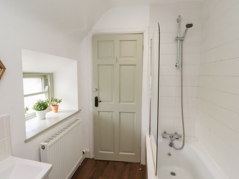 A bathroom with a bathtub and sink at Kits Cottage Middleton near Belford