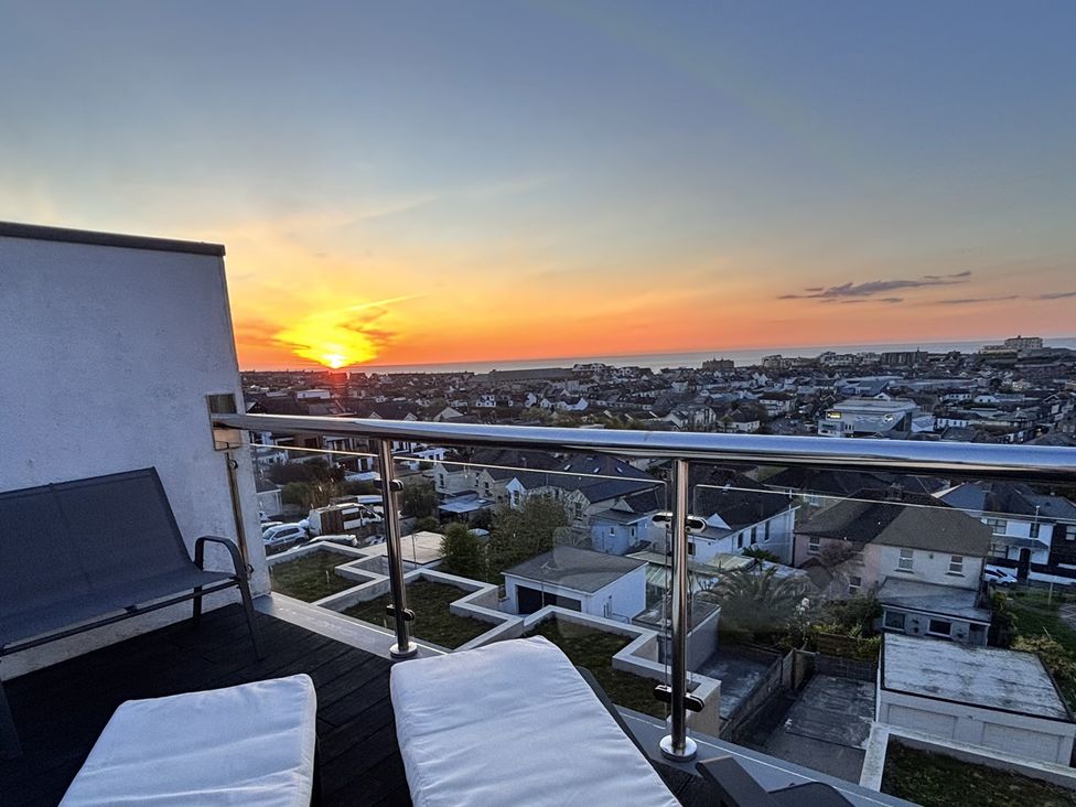 A balcony with chairs overlooking a town at 10 Quay Court in Newquay