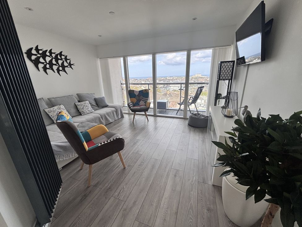 A living room with a sofa and armchair at 10 Quay Court in Newquay
