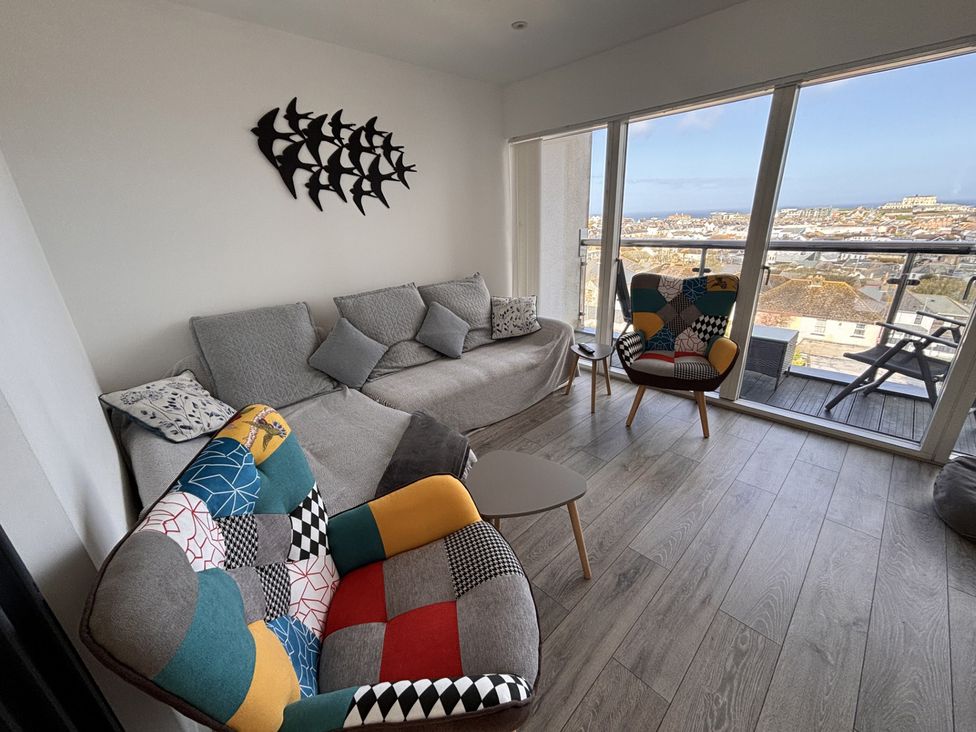 A living room with a sofa and chairs at 10 Quay Court in Newquay