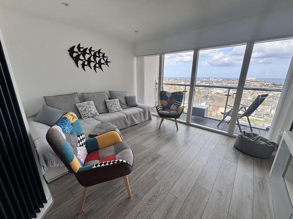 A living room with a sofa and chairs at 10 Quay Court in Newquay