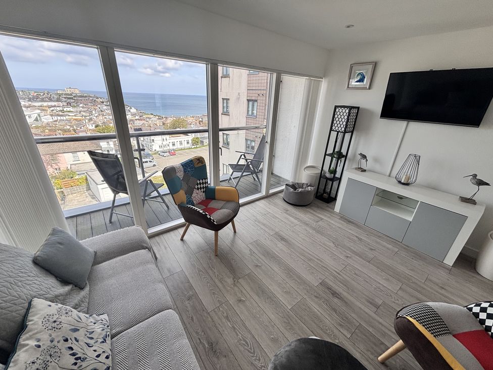 A living room with a sofa and armchair at 10 Quay Court in Newquay