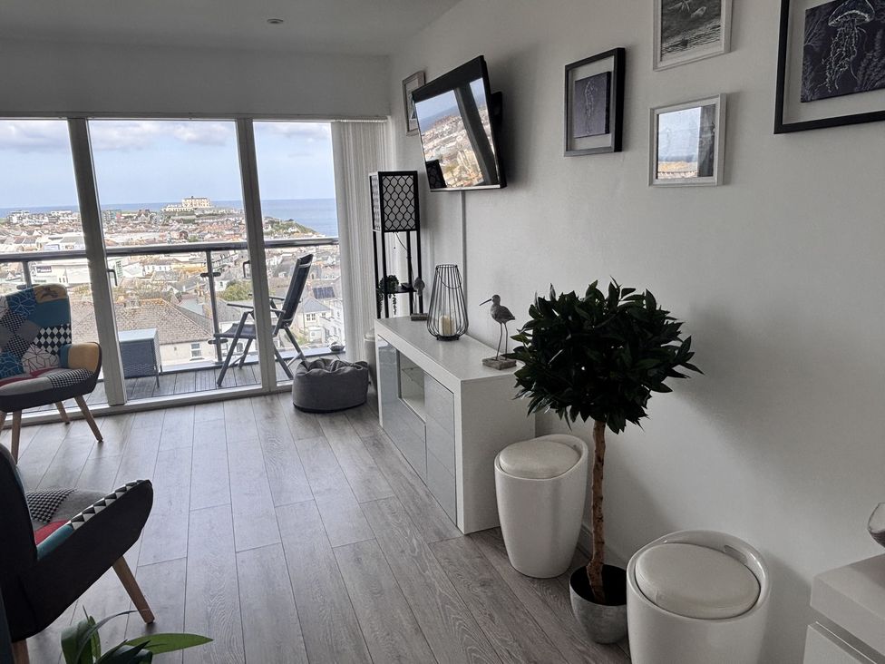 A living room with a balcony and a television at 10 Quay Court in Newquay
