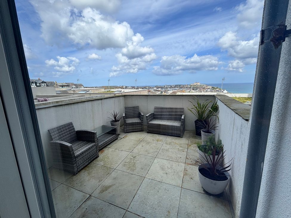 A terrace with chairs and a table at 10 Quay Court Newquay