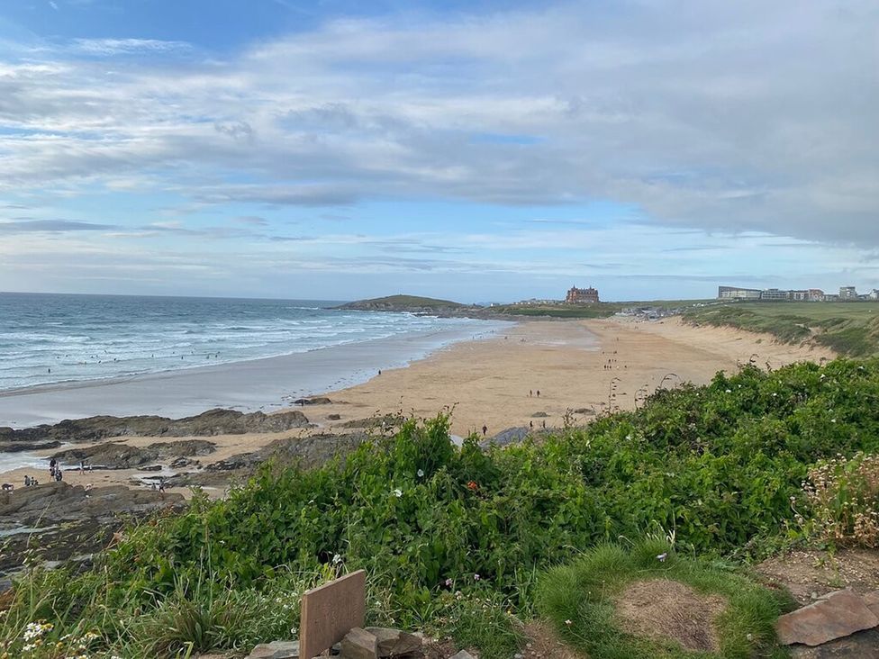 A beach with waves and people at 10 Quay Court Newquay