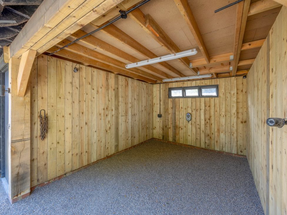 An empty storage room with wooden walls and windows at The Hayloft in Chislet near Herne Bay
