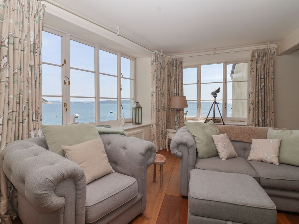 A living room with a telescope and windows showing the sea at Marina
