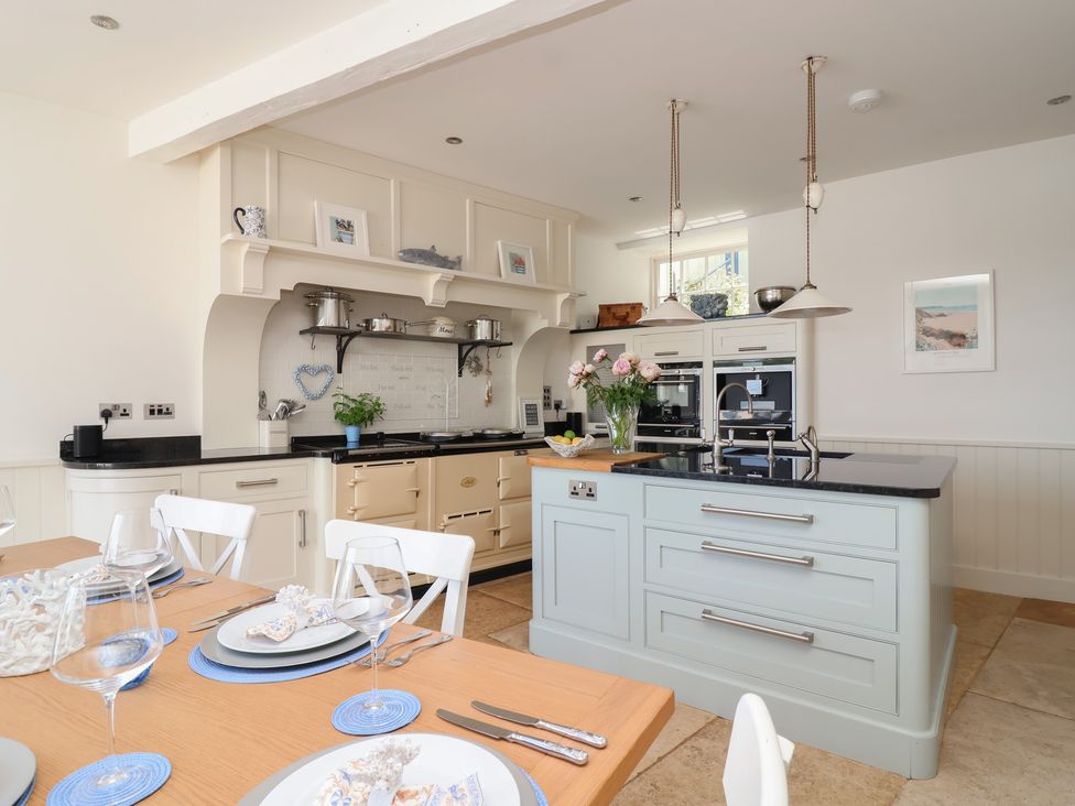 A kitchen with an island, stove, and dining table at Marina